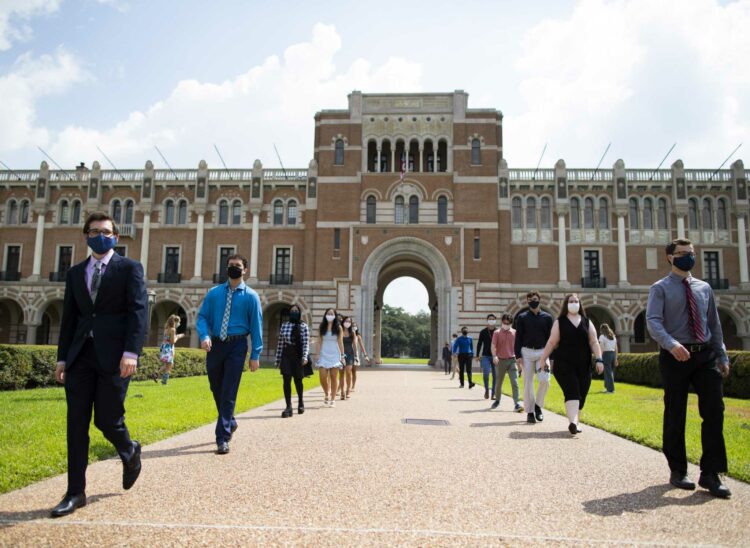 New Rice University students enter the Rice University quad on Friday, Aug. 21, 2020, in Houston as part of the ceremonial event on which the new students enter through the Sallport archway and more advance students welcome them with applause and signs. This year, the students were divided in groups of ten as safeguards against COVID-19.